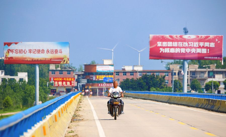 濛河特大桥横跨濛洼蓄洪区，村民从风机前骑过